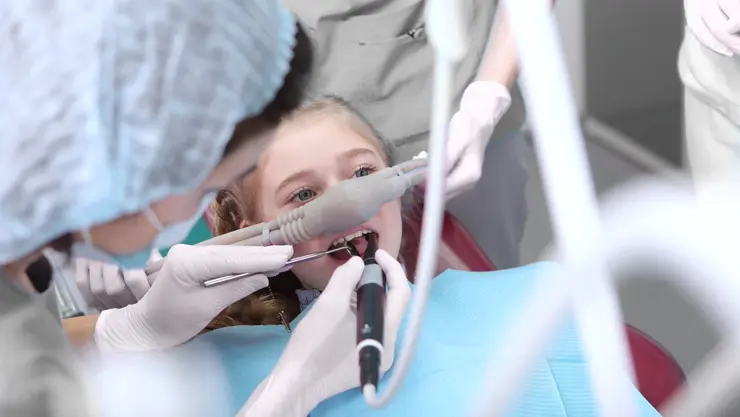 Junges Mädchen mit Lachgas-Maske während einer Zahnbehandlung