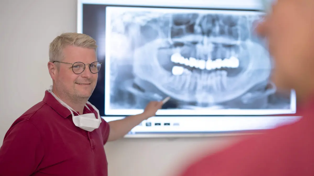 Zahnarzt Stefan Fortenbach erläutert Röntgenaufnahme